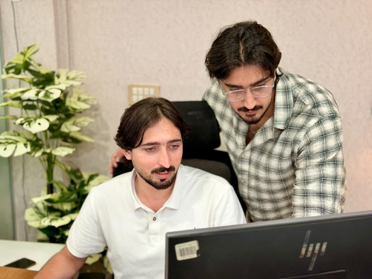Two ADYZER team members reviewing work together on screen